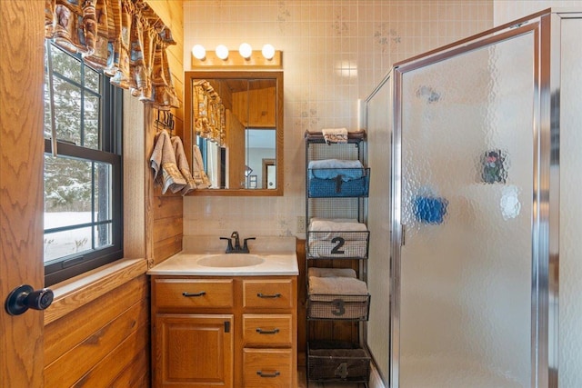 bathroom with vanity, backsplash, and walk in shower