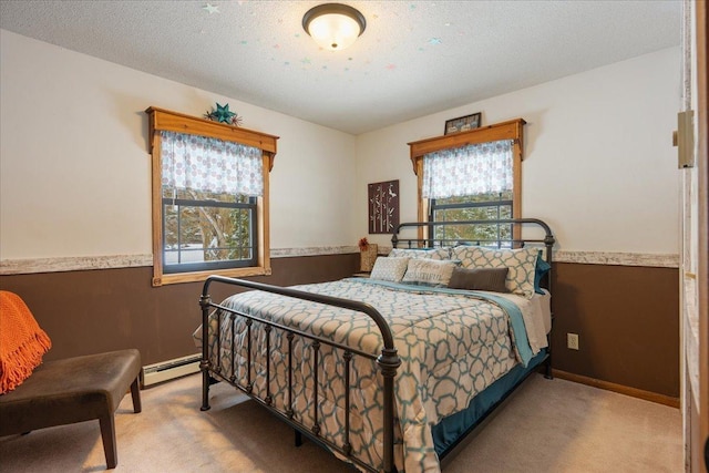 bedroom featuring baseboard heating, light carpet, and a textured ceiling