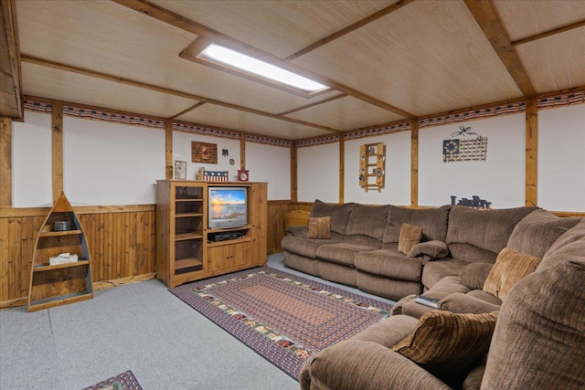 carpeted living room featuring wooden walls