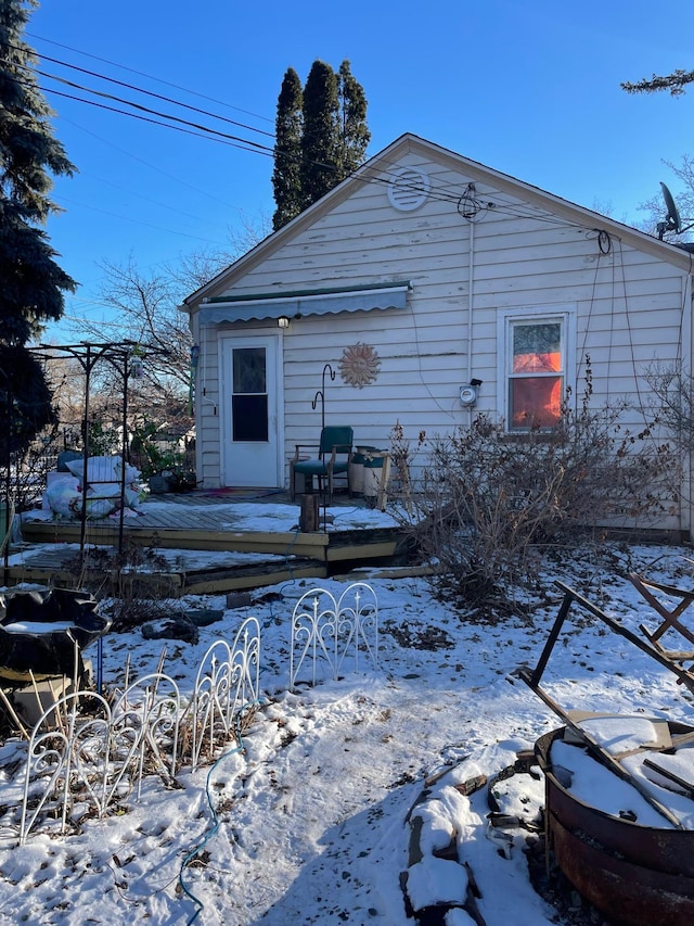 view of snow covered rear of property