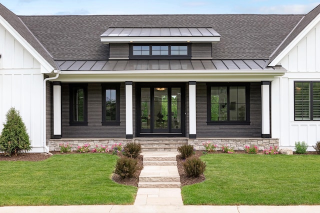 entrance to property featuring covered porch and a yard