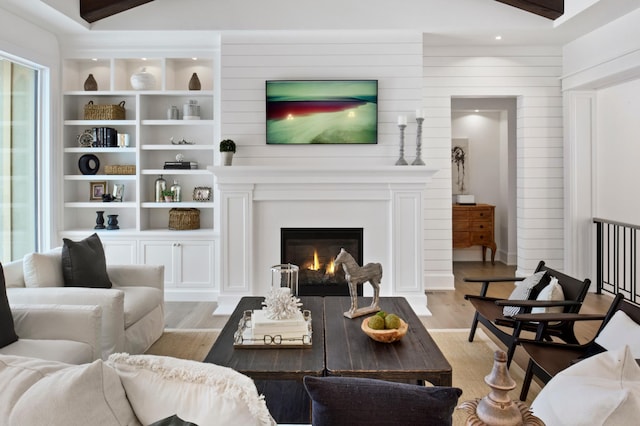 living room featuring beamed ceiling and light wood-type flooring