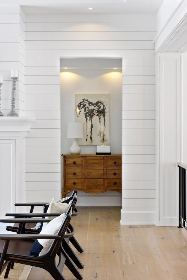 interior space featuring wooden walls and light hardwood / wood-style flooring