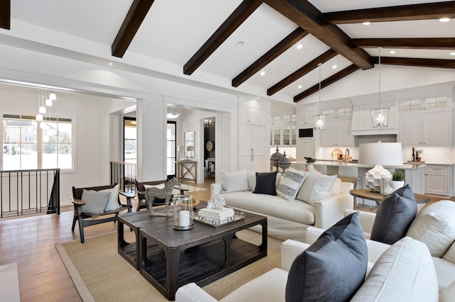 living room with beam ceiling, light hardwood / wood-style floors, and high vaulted ceiling