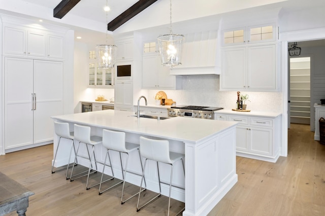 kitchen featuring white cabinets, beam ceiling, and sink