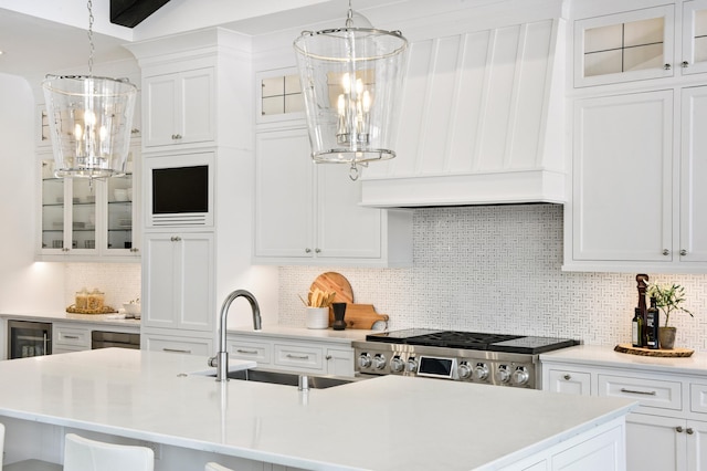 kitchen featuring tasteful backsplash, white cabinetry, and sink