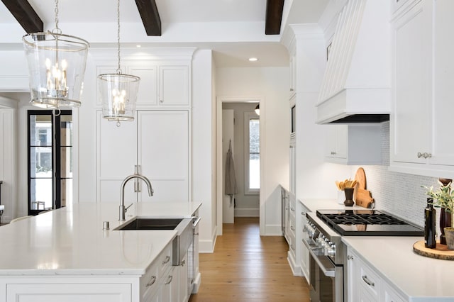 kitchen with white cabinets, premium range hood, decorative light fixtures, beamed ceiling, and stainless steel stove