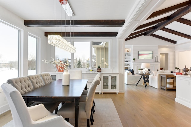 dining space with vaulted ceiling with beams, light wood-type flooring, and an inviting chandelier