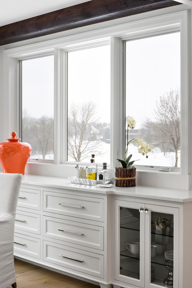 interior space featuring wine cooler, white cabinetry, and wood-type flooring