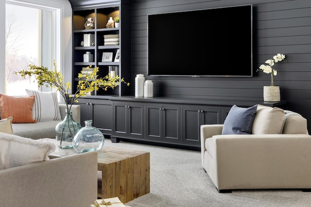 carpeted living room with wooden walls