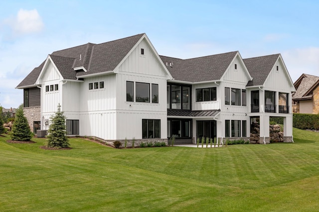 rear view of house featuring a lawn and central air condition unit