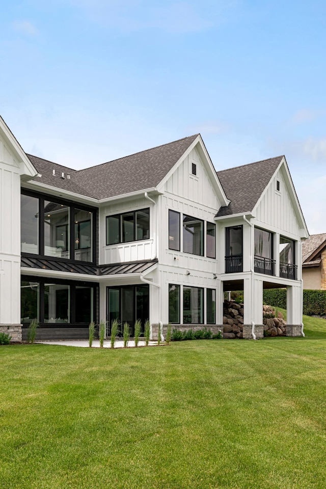 rear view of house with a yard and a sunroom