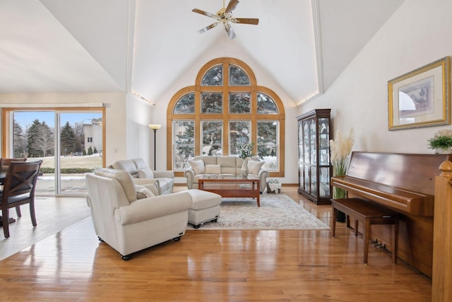 living room with high vaulted ceiling, light hardwood / wood-style floors, and ceiling fan