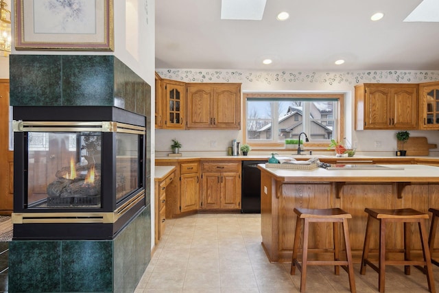 kitchen featuring a breakfast bar, a skylight, oven, a center island, and light tile patterned floors