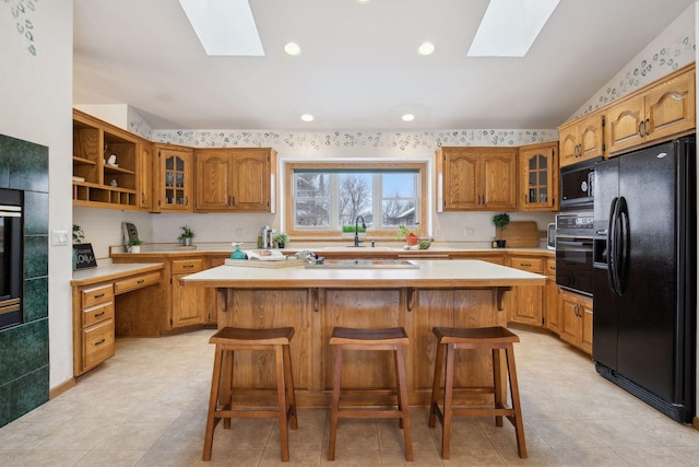 kitchen with a kitchen island, a kitchen bar, and black appliances