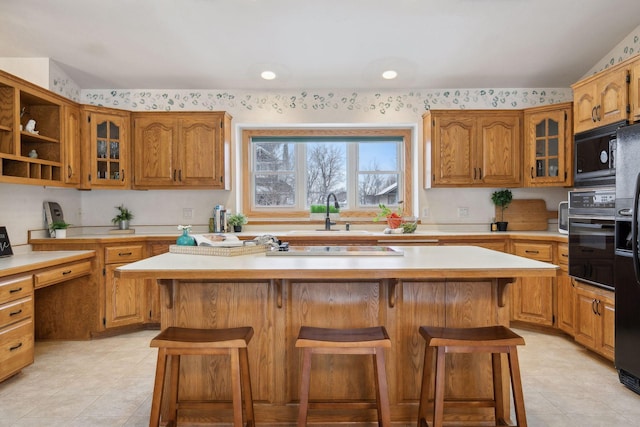 kitchen featuring a kitchen island, a kitchen bar, and black appliances