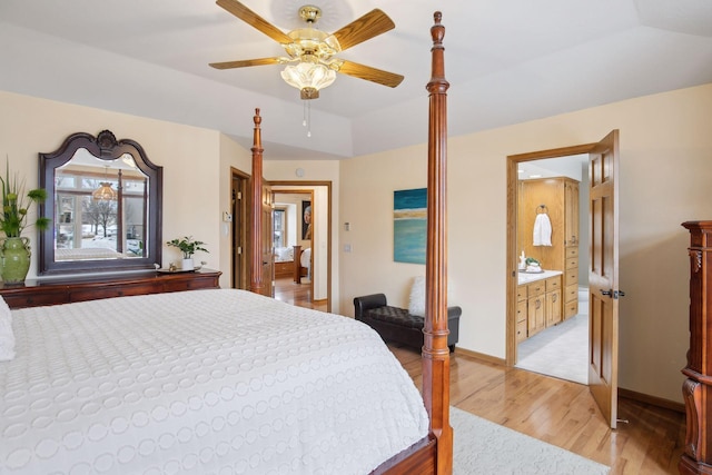 bedroom with lofted ceiling, ensuite bathroom, ceiling fan, and light wood-type flooring