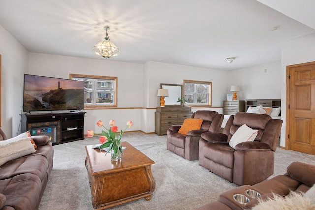 living room featuring light carpet and a notable chandelier