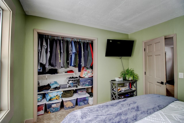 carpeted bedroom with a closet and a textured ceiling