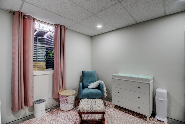 living area featuring a drop ceiling