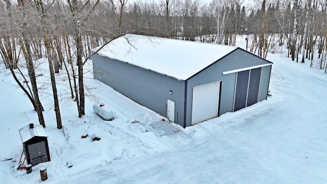 snow covered structure featuring a garage