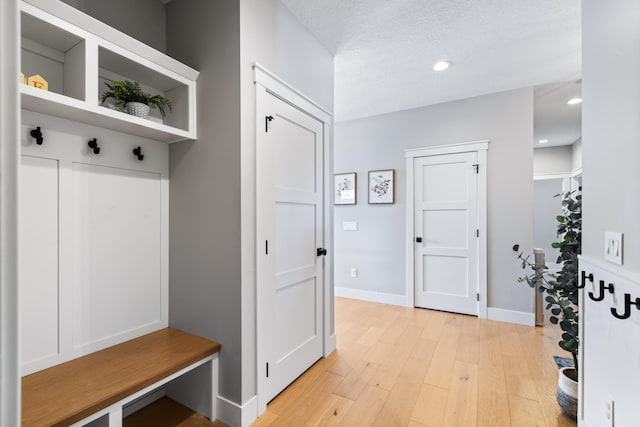 mudroom featuring a textured ceiling and light wood-type flooring