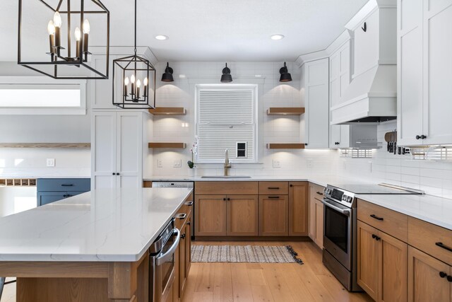 kitchen featuring white cabinets, a center island, sink, premium range hood, and stainless steel electric range