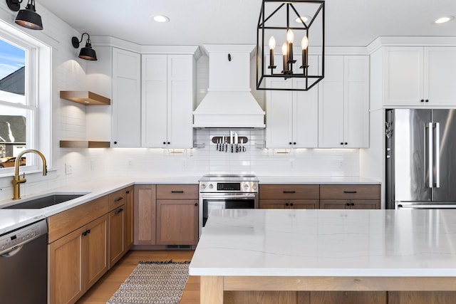 kitchen featuring sink, premium range hood, white cabinets, and stainless steel appliances