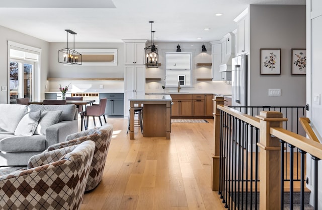 kitchen with a kitchen island, white cabinets, decorative light fixtures, and a breakfast bar