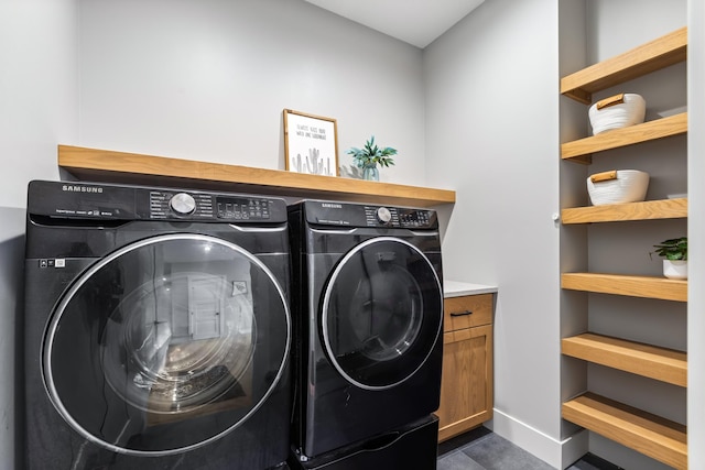 clothes washing area with cabinets and washing machine and dryer