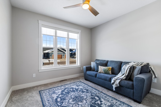 carpeted living room with ceiling fan