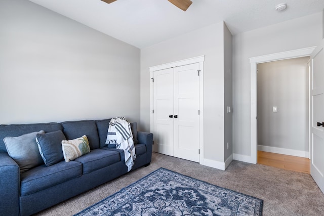 carpeted living room with ceiling fan