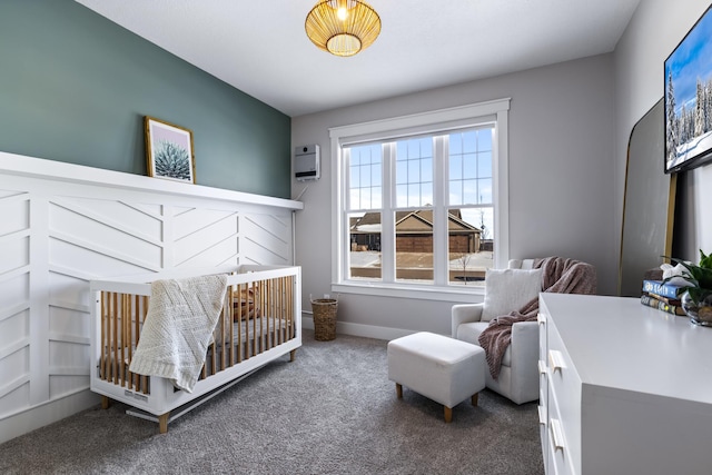 bedroom featuring a wall mounted air conditioner, carpet, and a crib