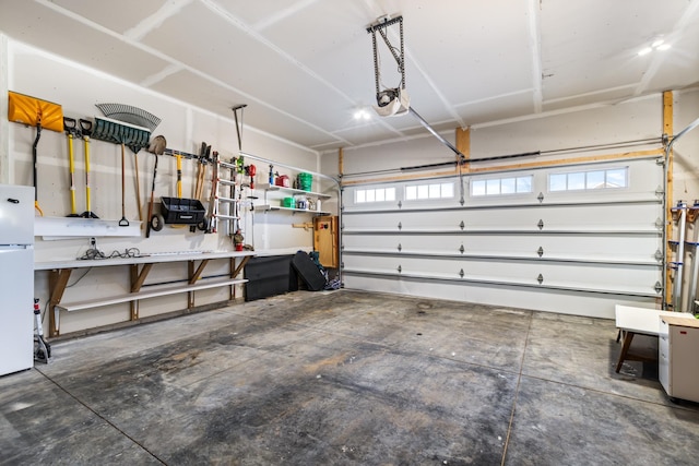 garage featuring white refrigerator and a garage door opener