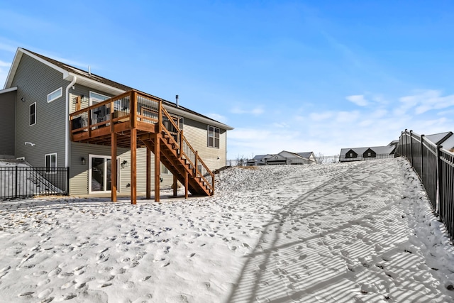 snow covered house with a wooden deck