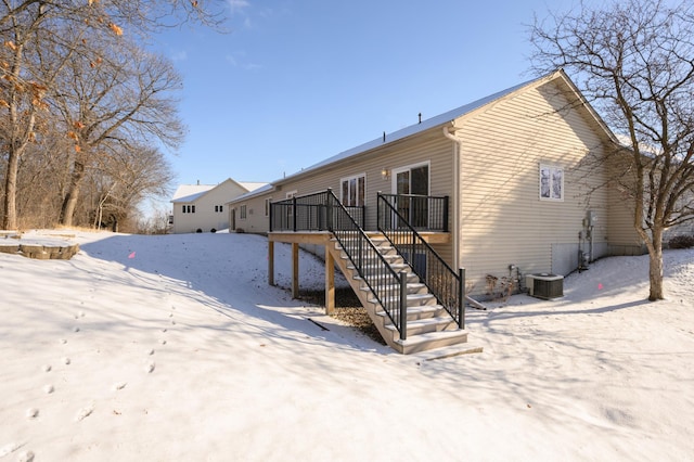 snow covered house featuring central AC