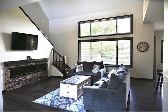 living room featuring dark hardwood / wood-style flooring, a fireplace, and a high ceiling