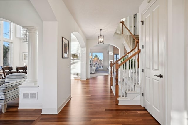 foyer featuring a healthy amount of sunlight, dark hardwood / wood-style flooring, and a notable chandelier