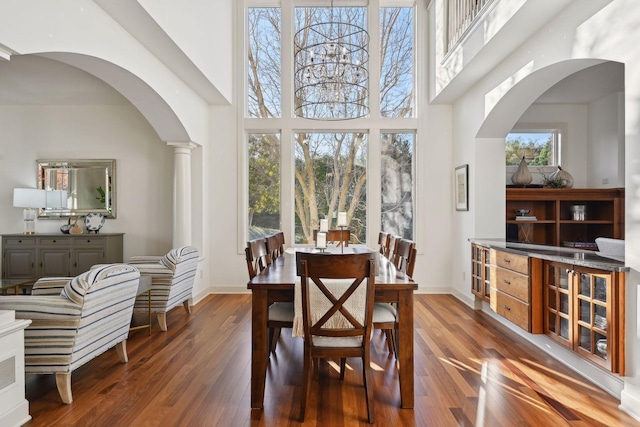 dining room with ornate columns, a wealth of natural light, and dark hardwood / wood-style floors