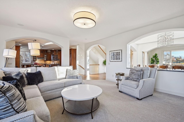 carpeted living room with a notable chandelier