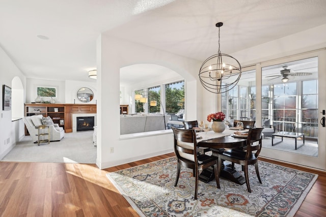 dining room with ceiling fan with notable chandelier and wood-type flooring