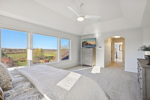 carpeted bedroom with ceiling fan and a tray ceiling