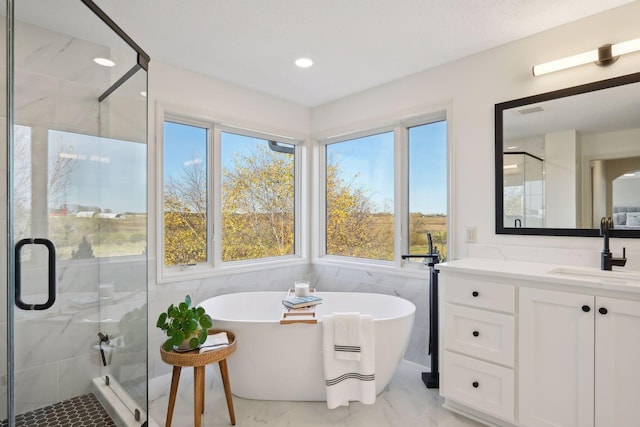 bathroom with independent shower and bath, tile walls, and vanity