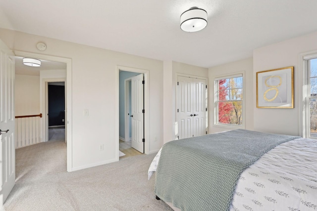 bedroom with multiple windows and light carpet