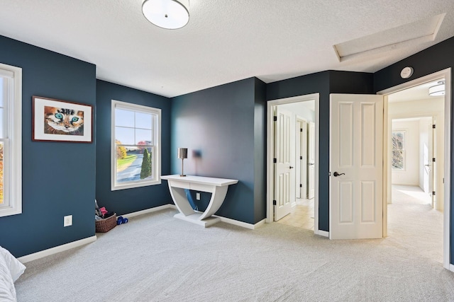 bedroom with a textured ceiling and light carpet