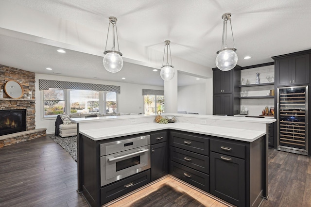 kitchen with a fireplace, wine cooler, a center island, and oven