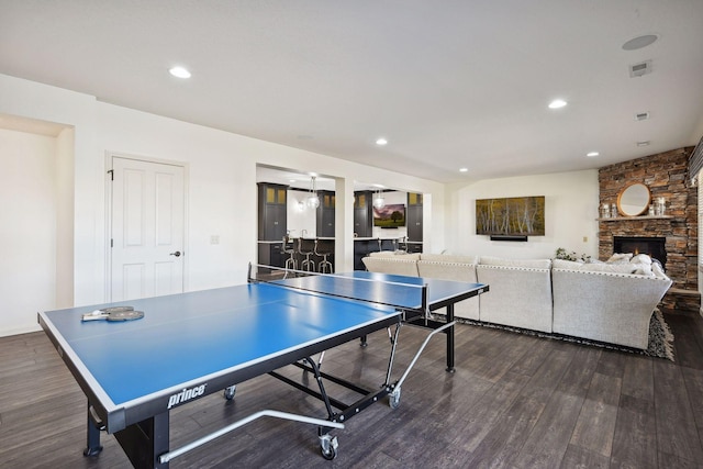 playroom with dark hardwood / wood-style floors and a stone fireplace