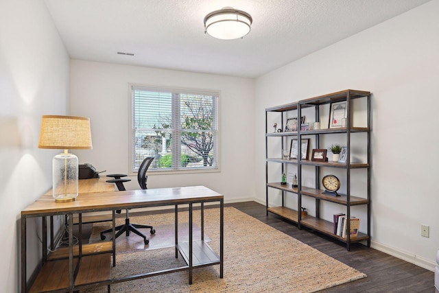 home office with dark hardwood / wood-style floors and a textured ceiling