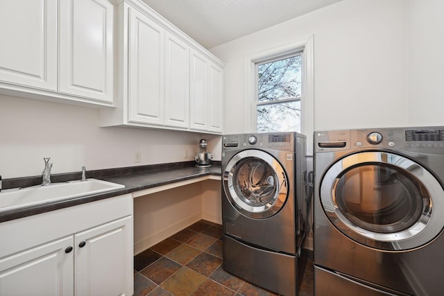 clothes washing area featuring washer and dryer, cabinets, and sink