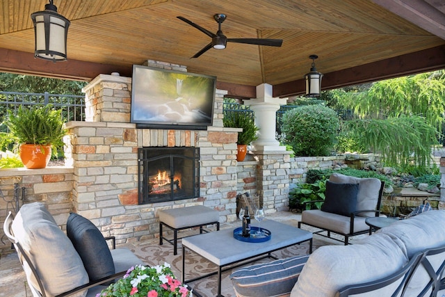 view of patio / terrace with ceiling fan and an outdoor living space with a fireplace